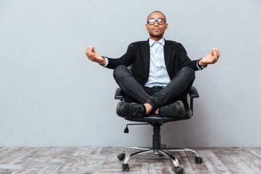 Mann im Bürostuhl beim Yoga
